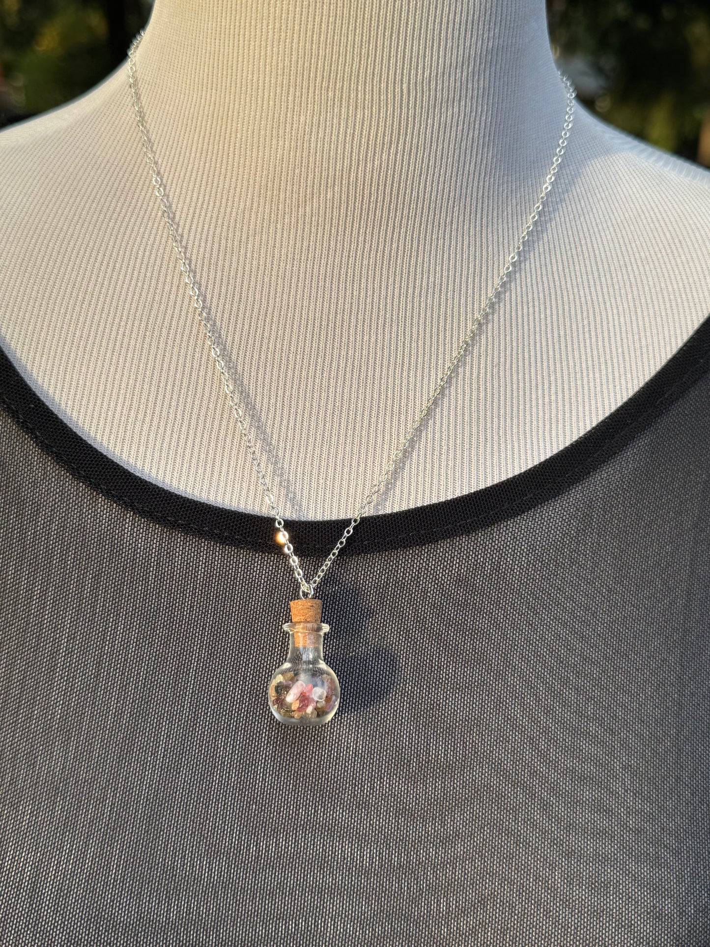 Glass bottle with rainbow tourmaline necklace