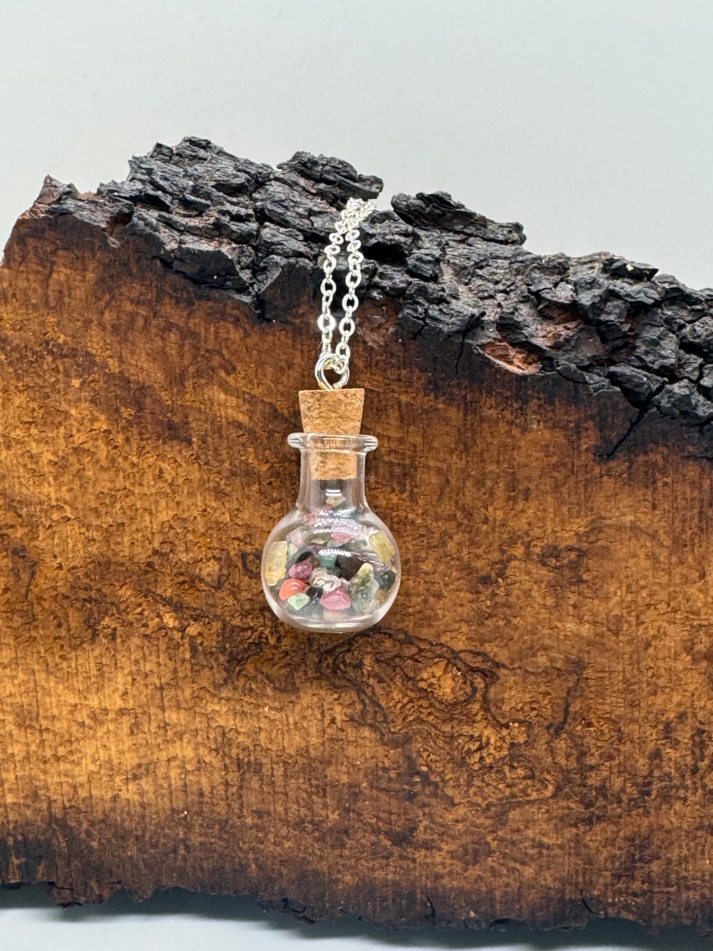 Glass bottle with rainbow tourmaline necklace