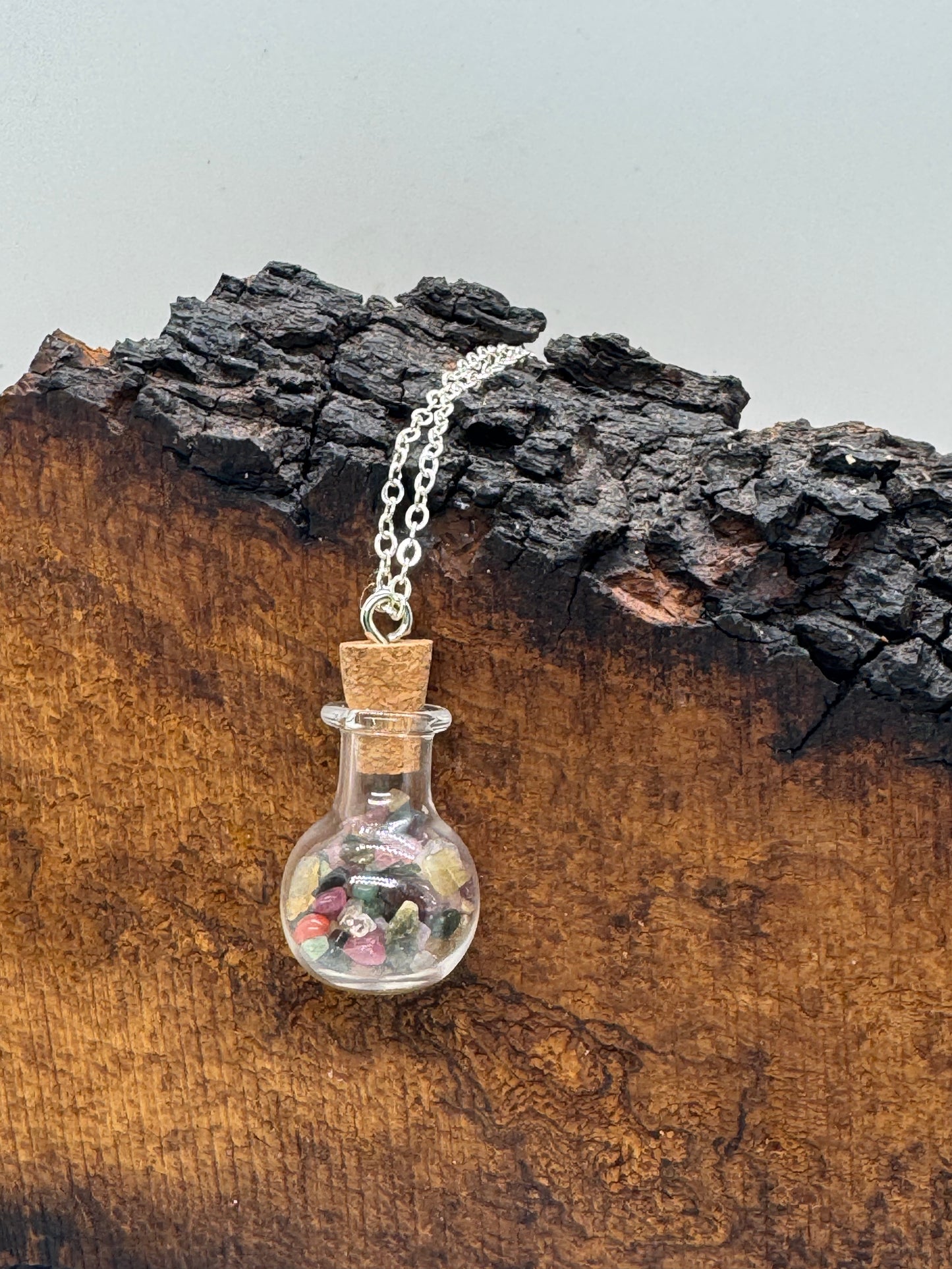 Glass bottle with rainbow tourmaline necklace